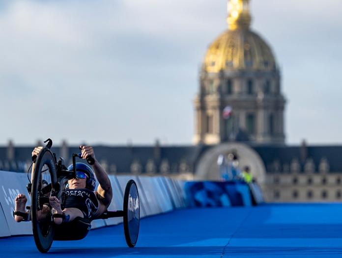A female athlete competes in a handcycle at Paris 2024.